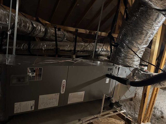 Air handler installed in an attic with multiple insulated supply ducts.