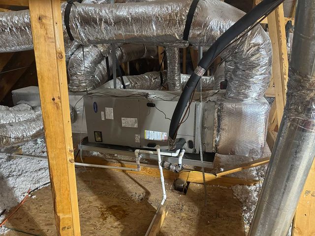 Complete residential attic HVAC system with insulated duct connections.