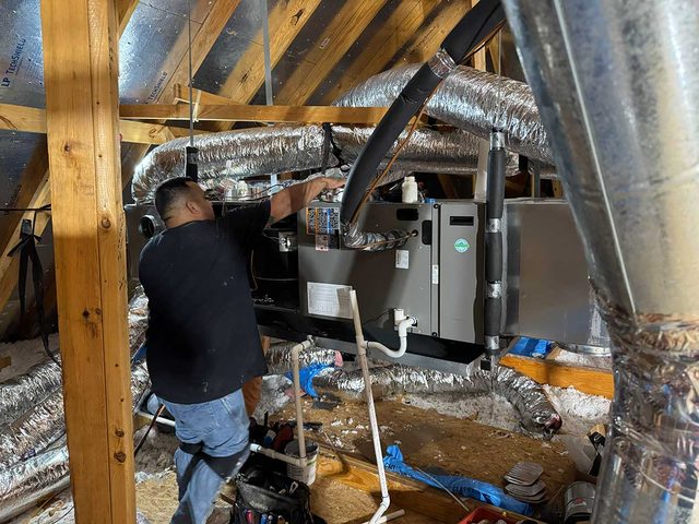 Technician working on a professionally installed attic HVAC system.