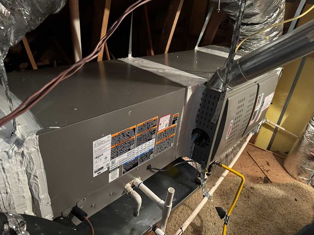 Horizontal attic air handler installed with refrigerant and drain connections.