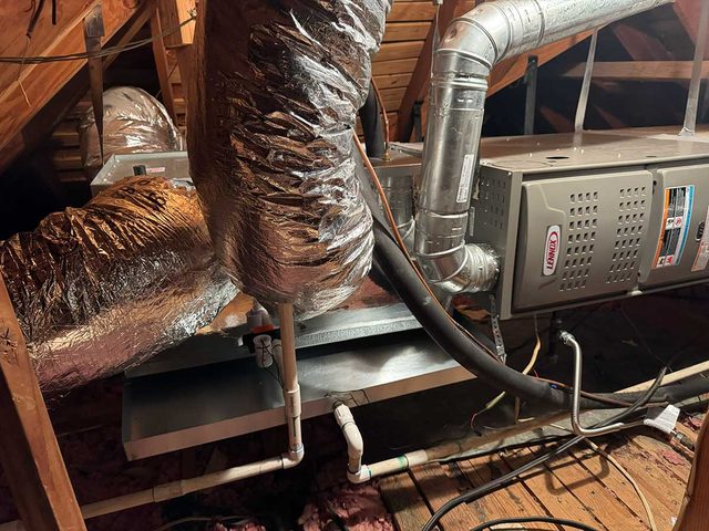Lennox HVAC system installed in an attic with insulated duct connections.