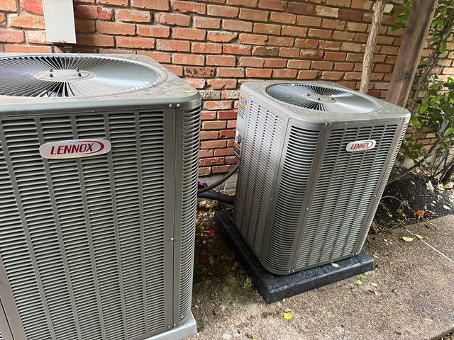 Pair of Lennox outdoor condenser units installed beside a brick building.