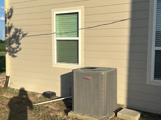 Outdoor air-conditioning condenser installed next to a residential property.